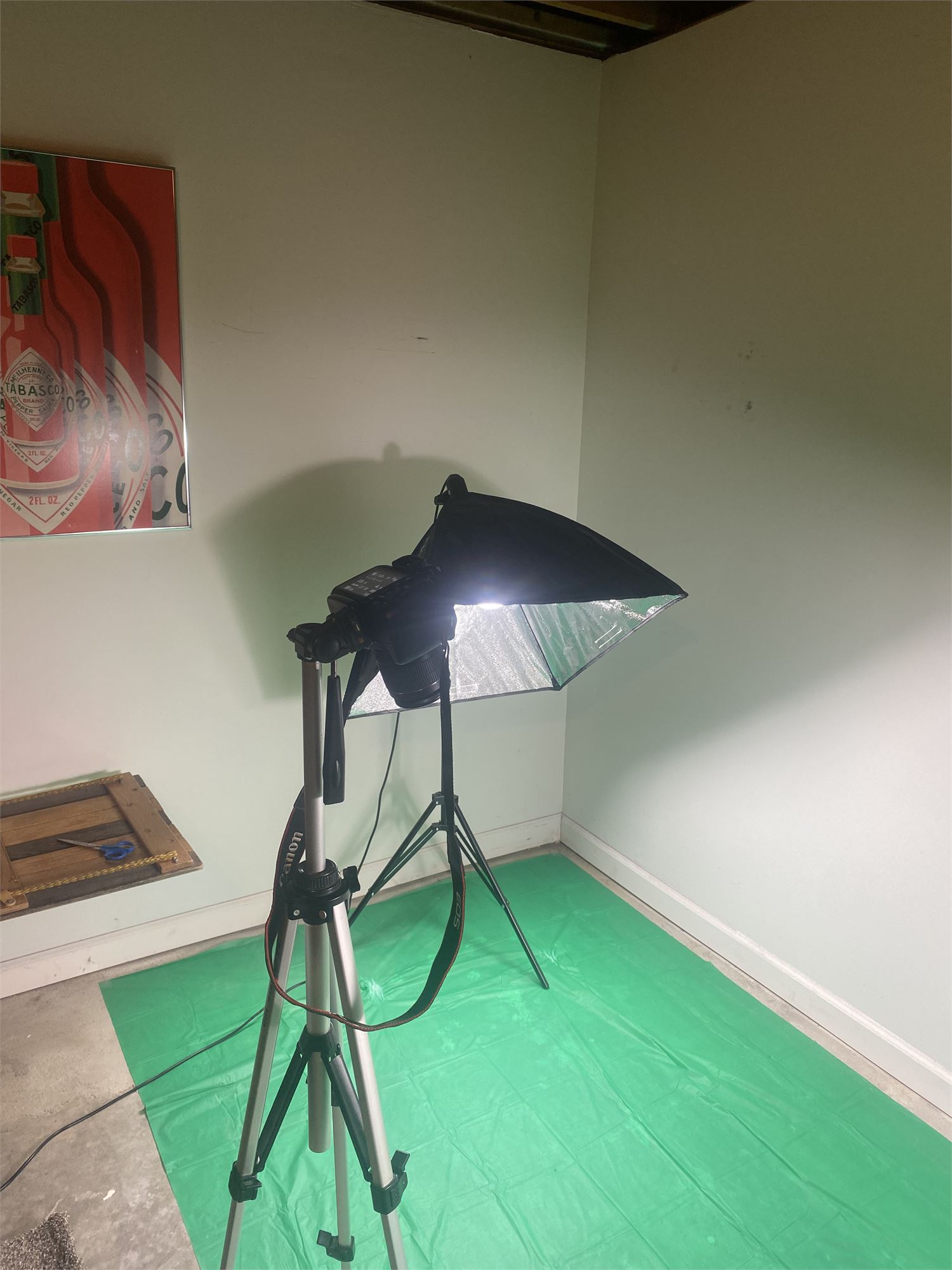 Early Barcode Garments studio setup: camera on a tripod with a softbox light over a green floor.